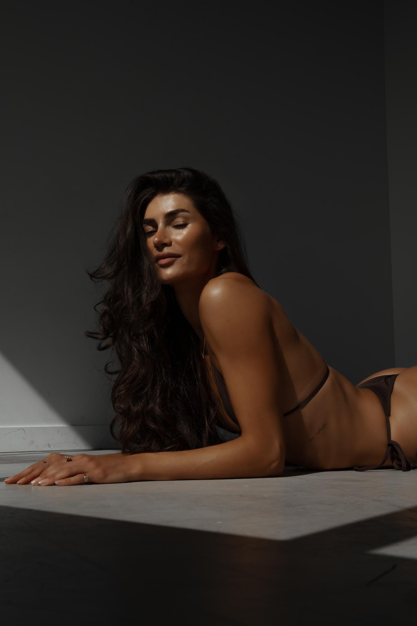 tanned model with long hair and glowing skin
